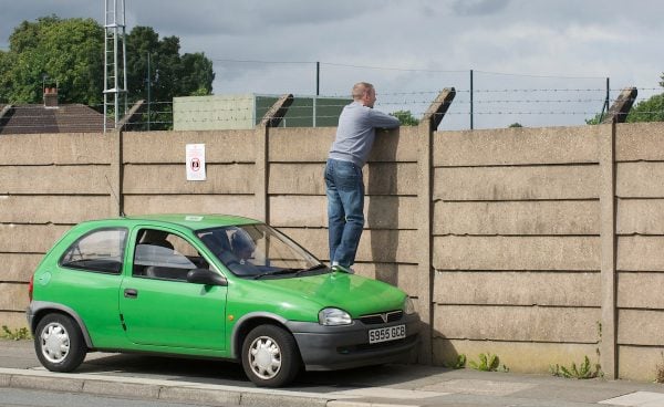 LIVERPOOL, ENGLAND - Wednesday, August 18, 2010: A Liverpool supporter uses his car to get a good vantage point to peer over the wall of the club's Melwood training ground to get a glimpse of the players training ahead of the UEFA Europa League Play-Off 1st Leg match against Trabzonspor A.S. (Pic by: David Rawcliffe/Propaganda)