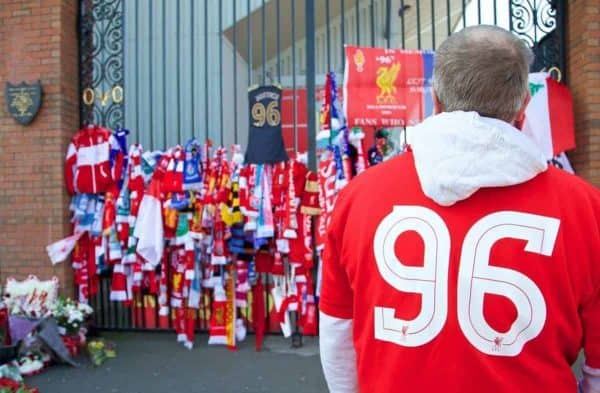 LIVERPOOL, ENGLAND - Tuesday, April 15, 2014: A supporter takes a moment to look at the tributes tied to the Shankly Gates before the 25th Anniversary Hillsborough Service at Anfield. (Pic by David Rawcliffe/Propaganda)