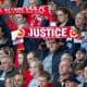 LIVERPOOL, ENGLAND - Tuesday, April 15, 2014: A Liverpool supporter holds up a scarf 'Justice' during the 25th Anniversary Hillsborough Service at Anfield. (Pic by David Rawcliffe/Propaganda)