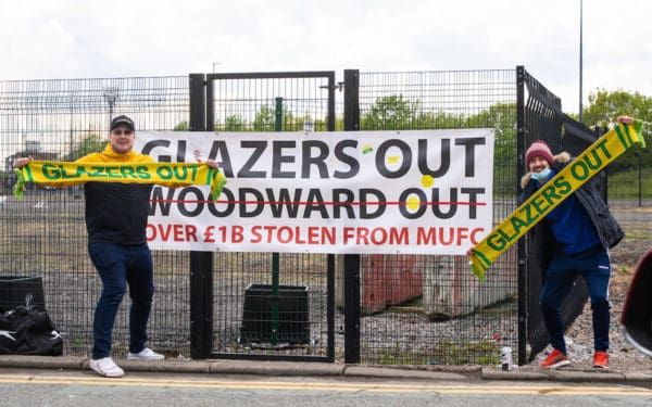 MANCHESTER, ENGLAND - Sunday, May 2, 2021: Two Manchester United supporters protest against the owners with "Glazers Out" scarves and banner outside the ground before the FA Premier League match between Liverpool FC and Manchester United FC at Old Trafford which was postponed due to safety concerns after a number of supporters entered the stadium. (Pic by David Rawcliffe/Propaganda)