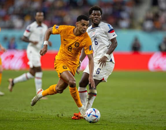 DOHA, QATAR - Saturday, December 3, 2022: Netherlands' Cody Gakpo (L) gets past USA's Yunus Musah during the FIFA World Cup Qatar 2022 Round of 16 match between Netherlands and USA at the Khalifa International Stadium. Netherlands won 3-1. (Pic by David Rawcliffe/Propaganda)