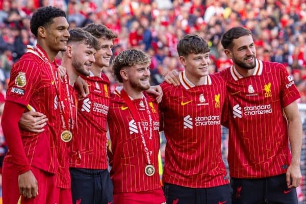 Liverpool players pose with the trophy after winning the premier league.