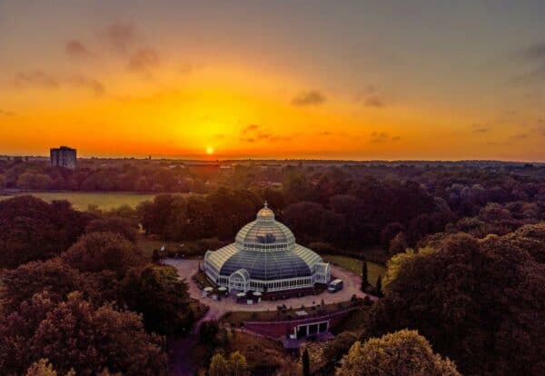 The sun rises behind the Sefton Park Palm House