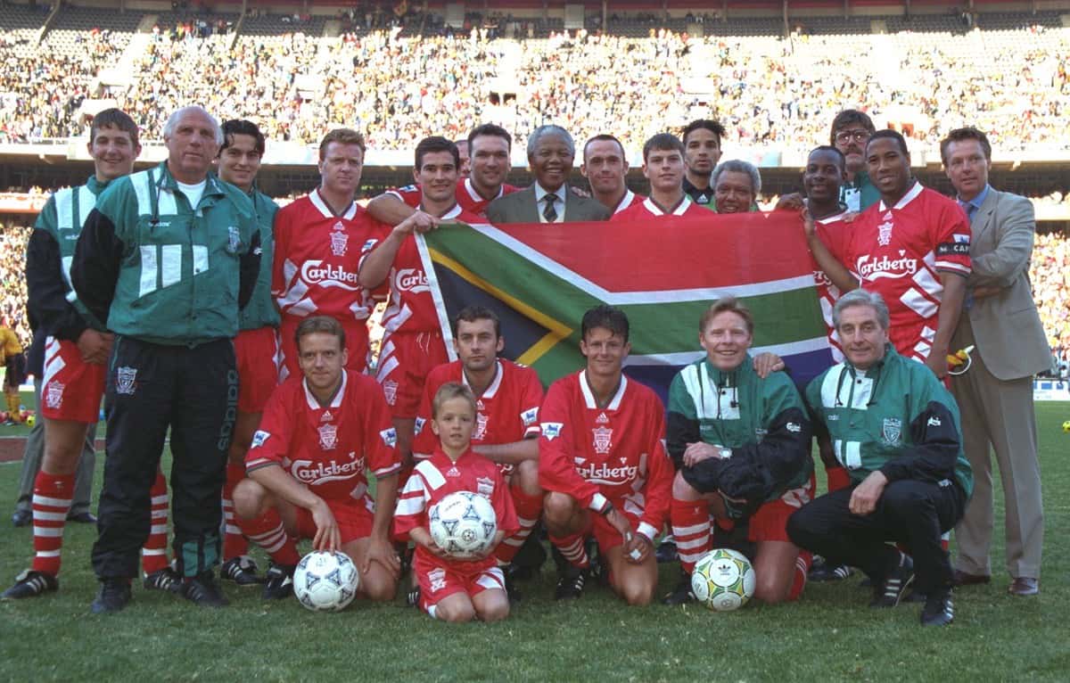 JOHANNESBURG, REPUBLIC OF SOUTH AFRICA - Sunday, May 29, 1994: Life supporter of Liverpool FC for life and newly elected President of the Southern Republic, Nelson Mandela, meets with Liverpool players during friendly match at Bank Football Festival United at Ellis Park Stadium. (Pic by David Rawcliffe / Propaganda) .. Back row LR: Andrew Harris, Coach Ronnie Moran, Iain Brunskill, Steve Nicol, Nigel Clough, Neil Ruddock, South African President Nelson Mandela, Ashley Neal, Phil Charnock, David James, Michael Thomas, physicist Max Thompson, John Barnes. First row L-R: Rob Jones, Don Hutchinson, Lee Jones, coach Sammy Lee, manager Roy Evans.