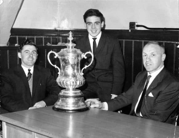 LIVERPOOL, ENGLAND - 1965: Liverpool FC manager Bill Shankly with the FA Cup trophy and two local journalists.