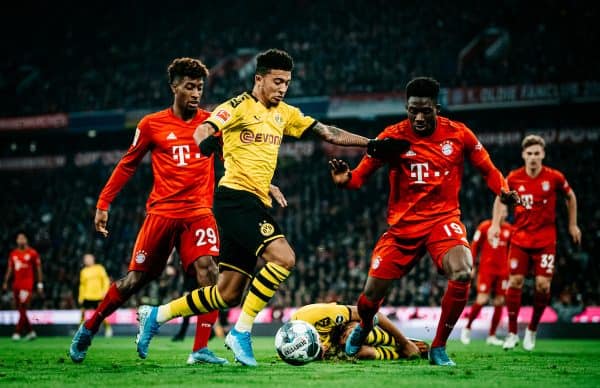 MUNICH, GERMANY - NOVEMBER 09: Jadon Sancho of Dortmund in action against Kingsley Coman of Bayern Muenchen (L) and Alphonso Davies of Bayern Muenchen during the Bundesliga match between FC Bayern M¸nchen and Borussia Dortmund at Allianz Arena on November 09, 2019 in Munich, Germany. (Photo by Alexander Scheuber/Bundesliga/Bundesliga Collection via Getty Images)