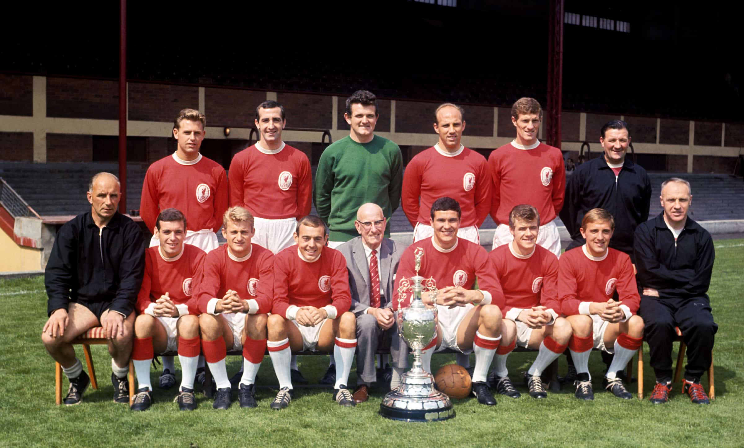 League champions Liverpool pose with the trophy: (back row, l-r) Gordon Milne, Gerry Byrne, Tommy Lawrence, Ronnie Moran, Wilf Stevenson, trainer Bob Paisley; (front row, l-r) trainer Reuben Bennett, Ian Callaghan, Roger Hunt, Ian St John, ?, Ron Yeats, Alf Arrowsmith, Peter Thompson, manager Bill Shankly. 12 August 1964. ( PA Photos/PA Archive/PA Images)