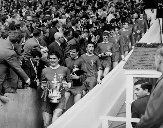 Liverpool captain Ron Yeats (l) carries the FA Cup down Wembley's 39 steps, followed by teammates Tommy Lawrence (carrying base of cup), Peter Thompson, Geoff Strong, Tommy Smith, Ian Callaghan, Wilf Stevenson, Chris Lawler, Roger Hunt, Ian St John and Gerry Byrne