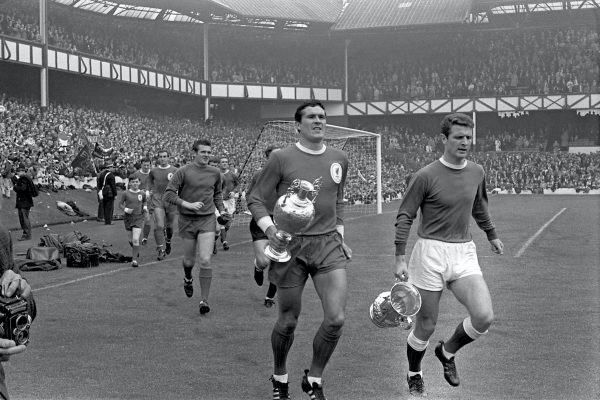 The two captains, Liverpool's Ron Yeats (second r) and Everton's Brian Labone (r), lead their teams on a lap of honour around Goodison Park before the match, carrying the trophies their teams won the previous season (Liverpool won the League Championship, Everton the FA Cup) 1966 (PA Photos/PA Archive/PA Images)