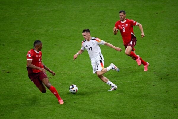 FRANKFURT AM MAIN, GERMANY - JUNE 23: Florian Wirtz of Germany runs with the ball whilst under pressure from Manuel Akanji of Switzerland during the UEFA EURO 2024 group stage match between Switzerland and Germany at Frankfurt Arena on June 23, 2024 in Frankfurt am Main, Germany. (Photo by Charles McQuillan - UEFA/UEFA via Getty Images)